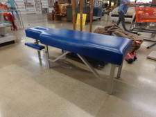 BLUE MASSAGE TABLE WITH FACE-DOWN COMFORTS.  
We have others folded ones available also when this was posted.  
$225.00
